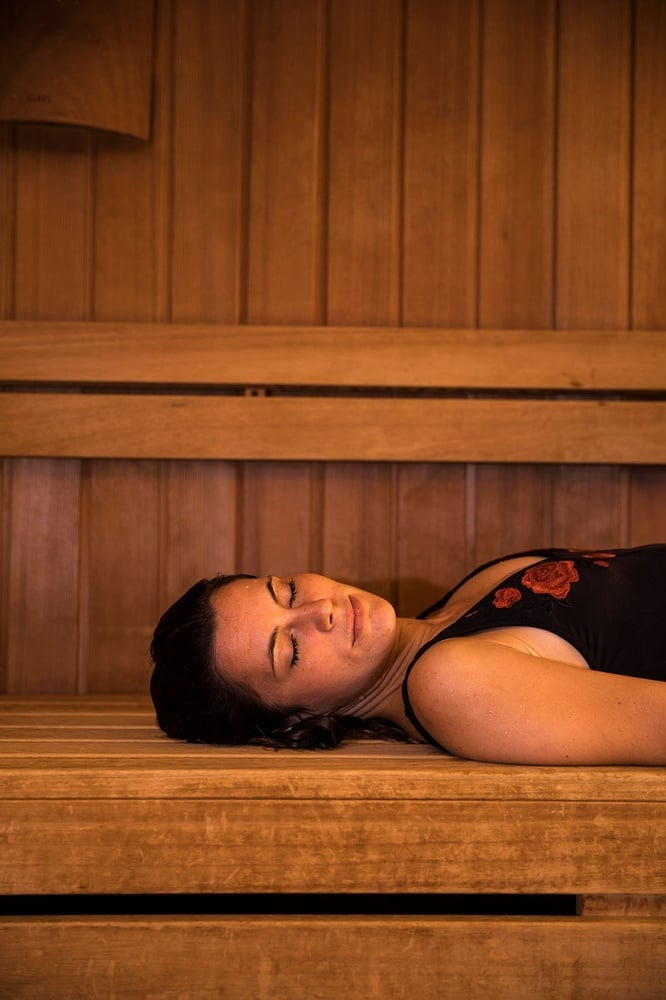 Huésped relajándose en la sauna de madera del hotel.