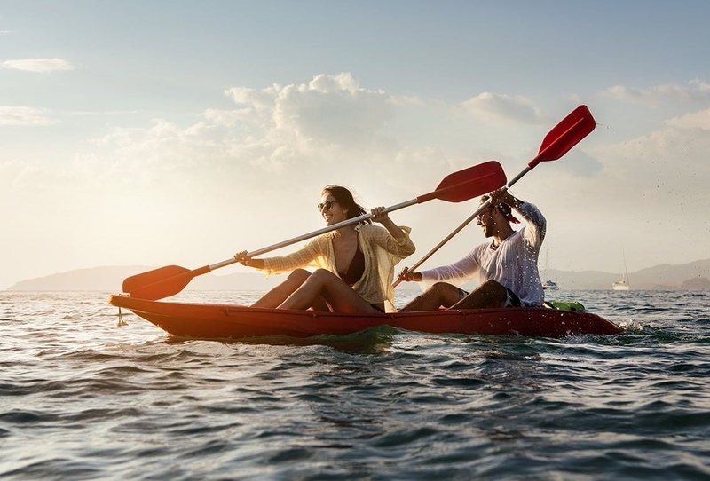 Pareja en kayak en el mar al atardecer. Experiencia de vacaciones.