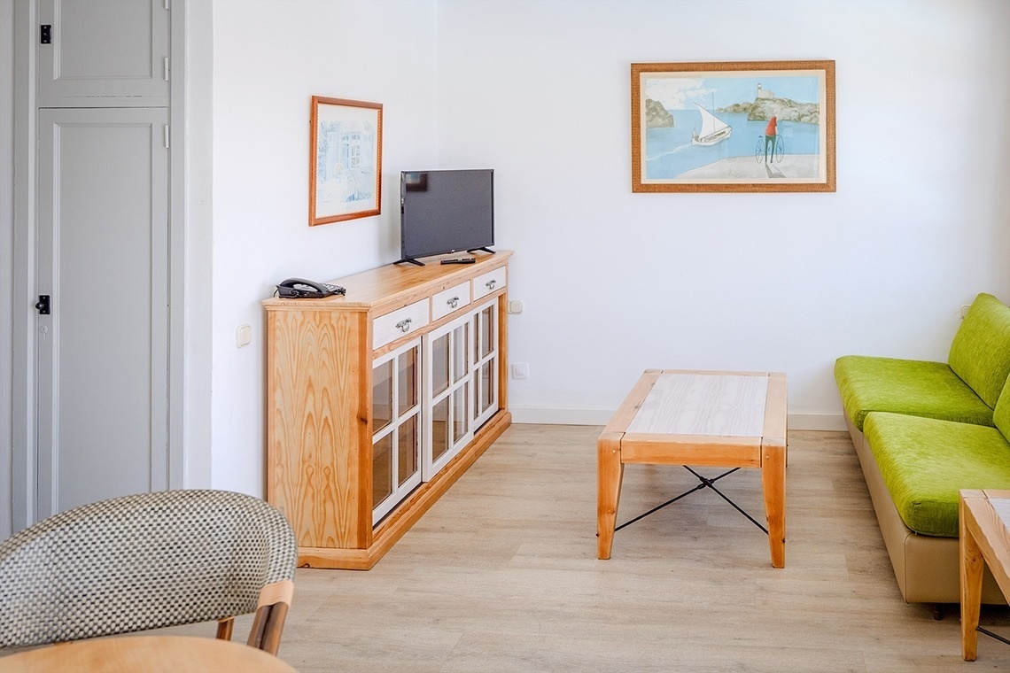 a living room with a green couch and a tv