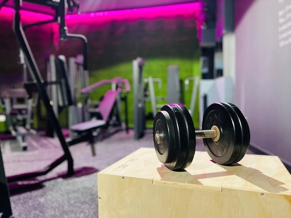 Gimnasio moderno de hotel con mancuernas y máquinas.