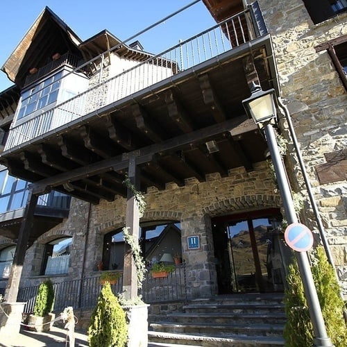 un edificio de piedra con una puerta de madera y una señal de no estacionar