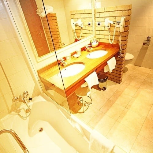 un baño con dos lavabos y una bañera