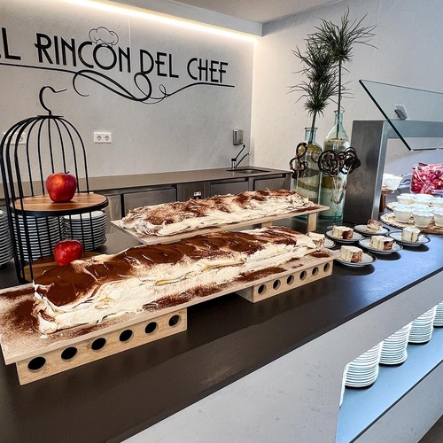 un restaurante lleno de mesas y sillas y un mostrador de ensaladas