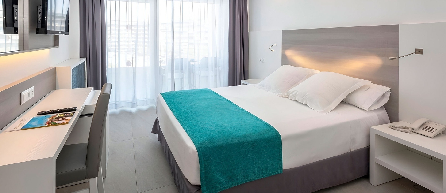 una habitación de hotel con una cama y un escritorio