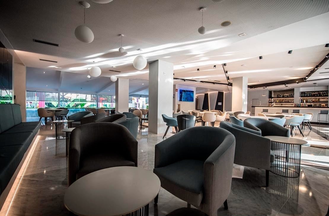 a variety of cheeses on a cutting board with a jar of honey in the background