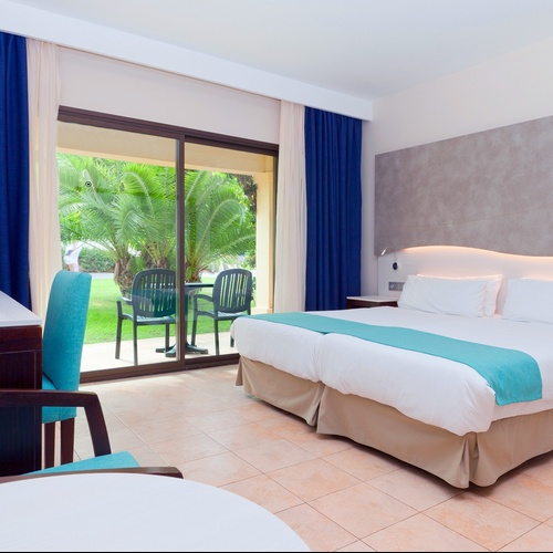 ein Balkon mit zwei Stühlen und einem Tisch mit einer Flasche Wasser darauf