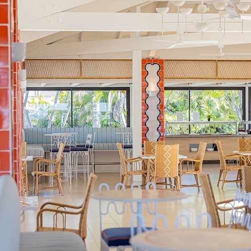 ein Raum mit weißen Tischen und Stühlen und einem Kronleuchter