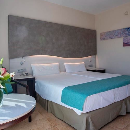 ein Balkon mit zwei Stühlen und einem Tisch mit einer Flasche Wasser darauf