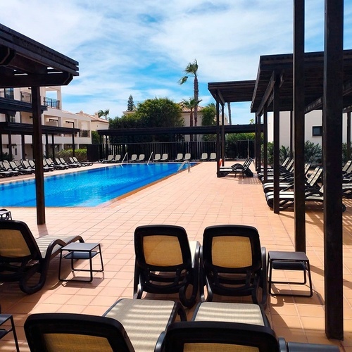 Liegestühle stehen neben einem großen Swimmingpool