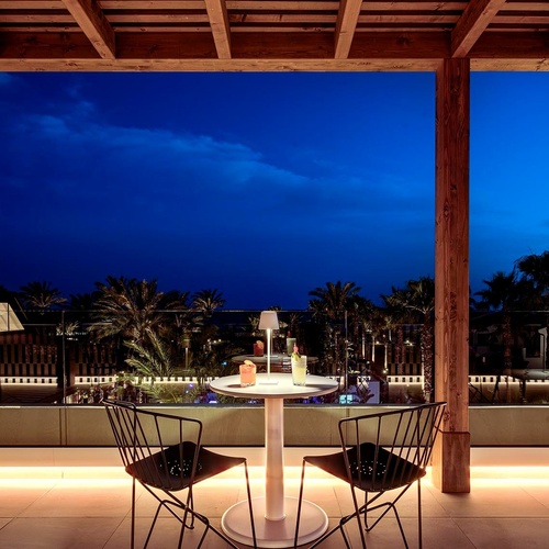 ein Raum mit weißen Tischen und Stühlen und einem Kronleuchter