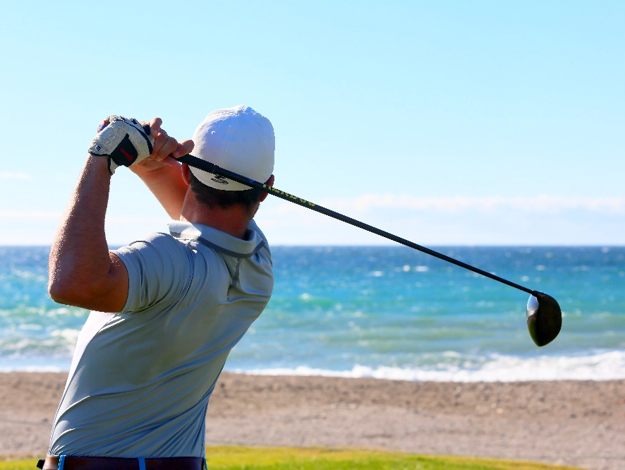 ein Mann und eine Frau spielen mit einem Volleyball am Strand