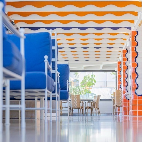 ein Raum mit weißen Tischen und Stühlen und einem Kronleuchter