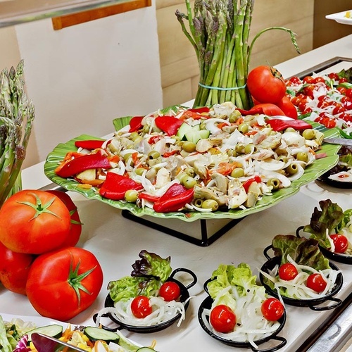 ein Raum mit weißen Tischen und Stühlen und einem Kronleuchter