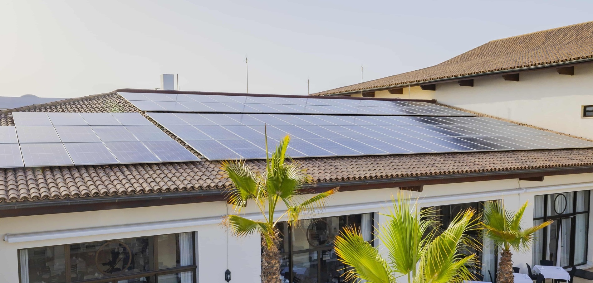 un restaurant avec des tables et des chaises et des panneaux solaires sur le toit