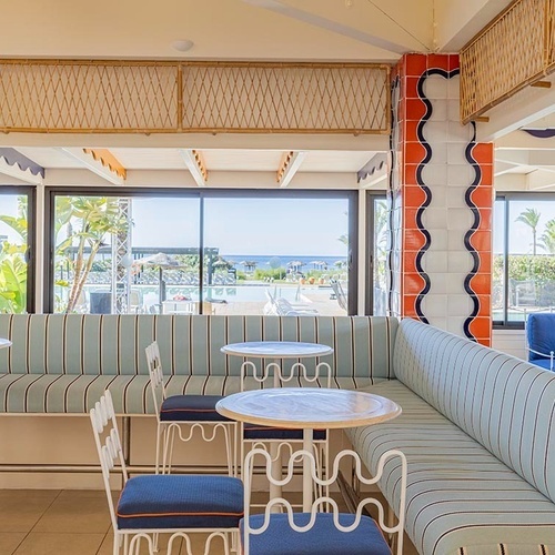 ein Raum mit weißen Tischen und Stühlen und einem Kronleuchter