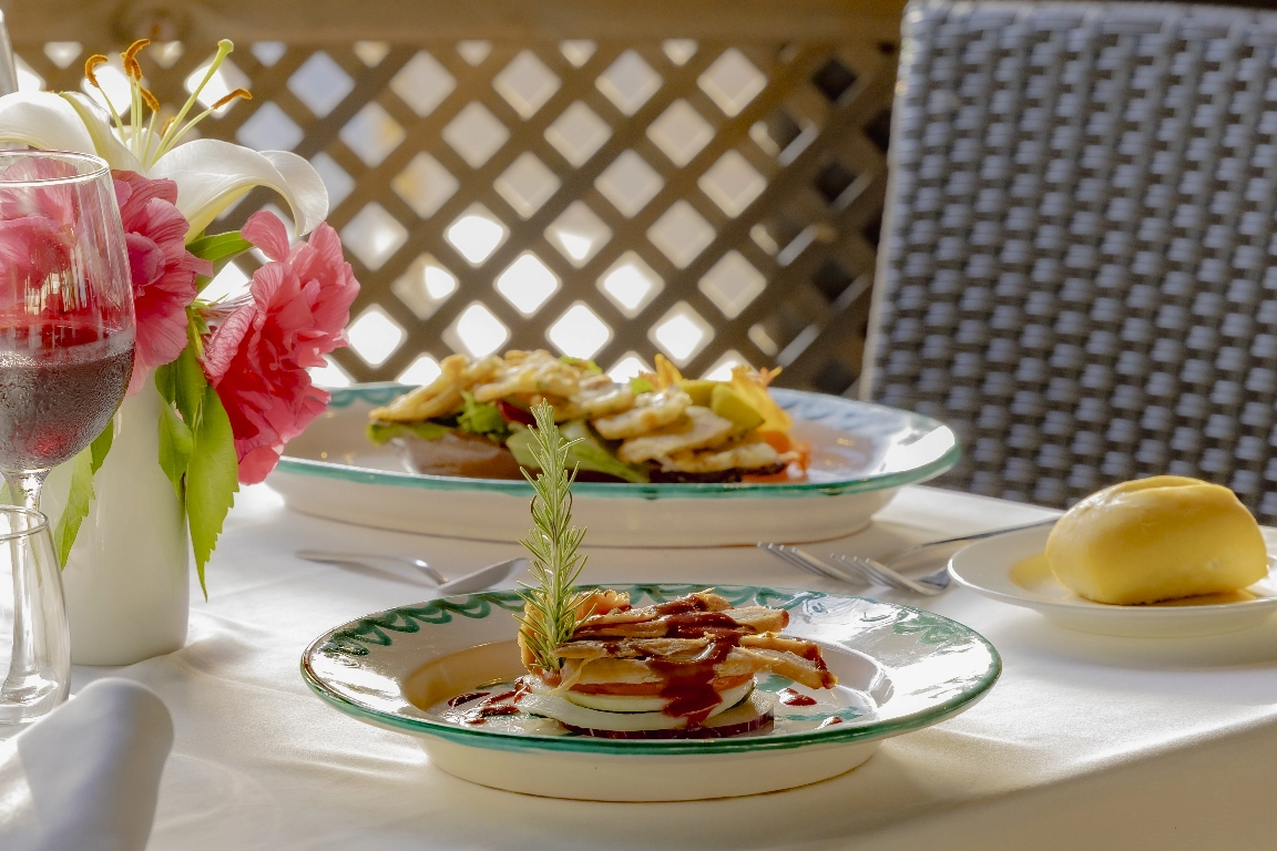 una mesa con platos de comida y un vaso de vino