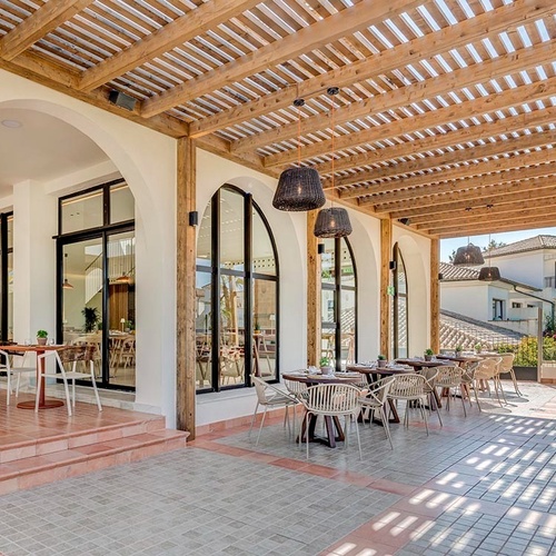 ein Raum mit weißen Tischen und Stühlen und einem Kronleuchter