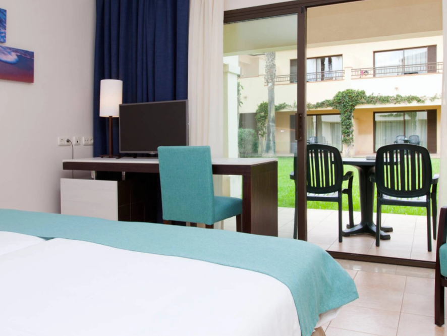 una habitación con una cama y una silla con vista al océano