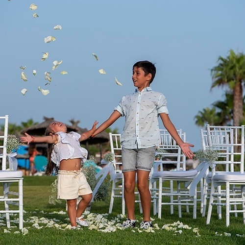 ein Raum mit weißen Tischen und Stühlen und einem Kronleuchter