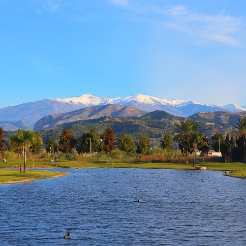 ein Golfplatz mit schneebedeckten Bergen im Hintergrund
