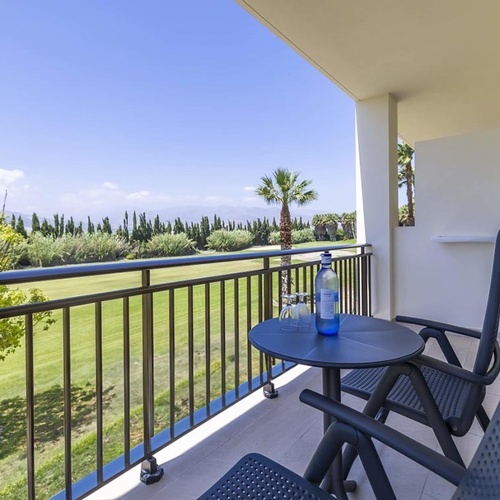 eine Flasche Wasser sitzt auf einem Tisch auf einem Balkon