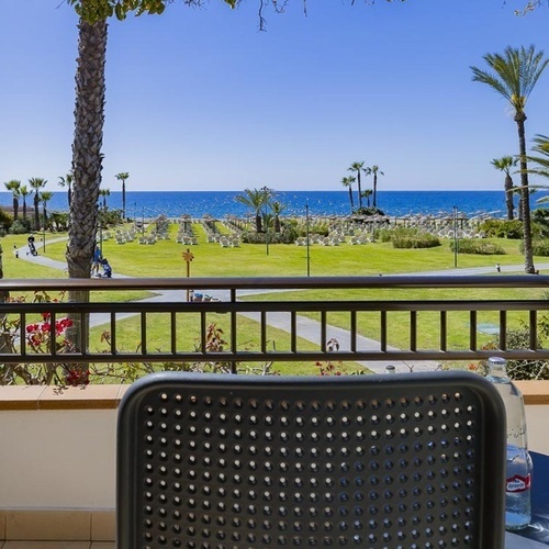 ein Tisch und ein Stuhl auf einem Balkon mit Blick auf den Ozean