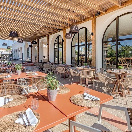 ein Raum mit weißen Tischen und Stühlen und einem Kronleuchter