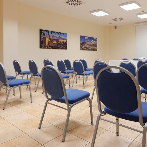 ein Raum mit weißen Tischen und Stühlen und einem Kronleuchter