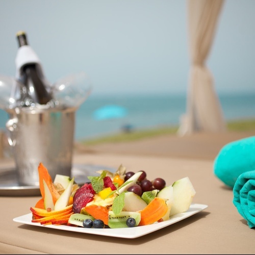 ein Raum mit weißen Tischen und Stühlen und einem Kronleuchter