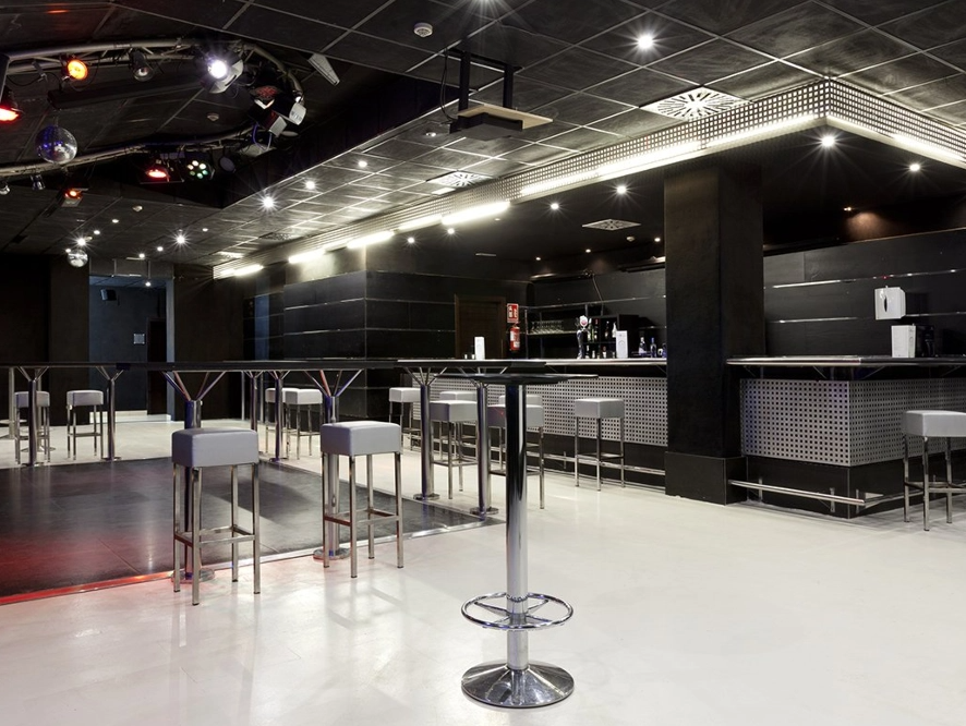 ein Raum mit hohen Tischen und Stühlen und einer Bar