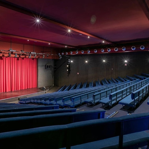 ein Raum mit weißen Tischen und Stühlen und einem Kronleuchter