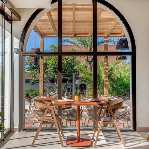 ein Raum mit weißen Tischen und Stühlen und einem Kronleuchter