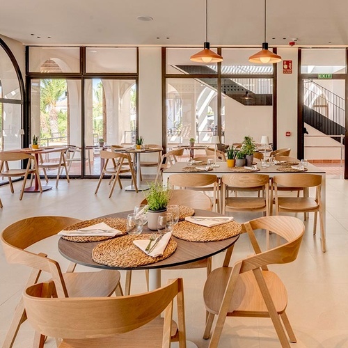 ein Raum mit weißen Tischen und Stühlen und einem Kronleuchter