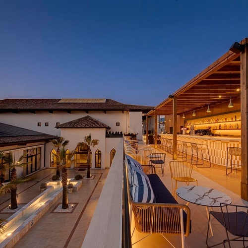 ein Raum mit weißen Tischen und Stühlen und einem Kronleuchter