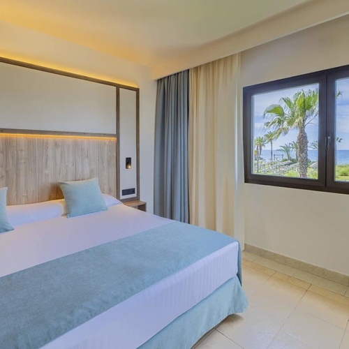 ein Schlafzimmer mit einem Bett und einem Fenster mit Blick auf das Meer