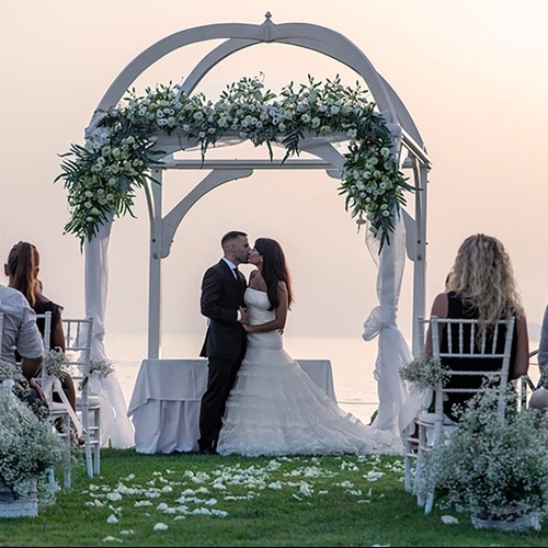 eine Braut und Bräutigam küssen sich während einer Hochzeitszeremonie