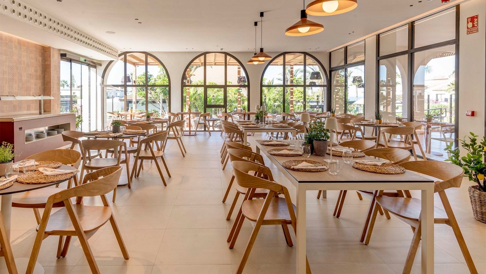 un restaurante con muchas mesas y sillas y una señal de extintor en la pared