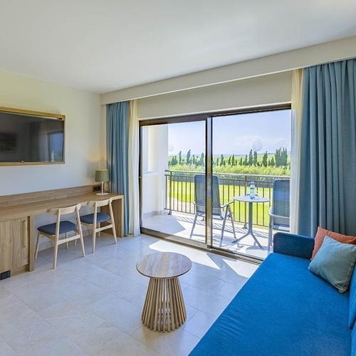 ein Balkon mit zwei Stühlen und einem Tisch mit einer Flasche Wasser darauf