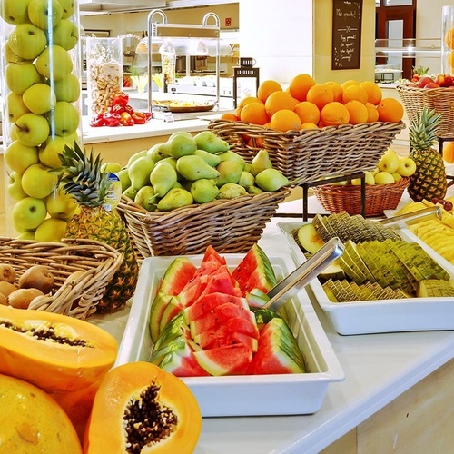 ein Raum mit weißen Tischen und Stühlen und einem Kronleuchter