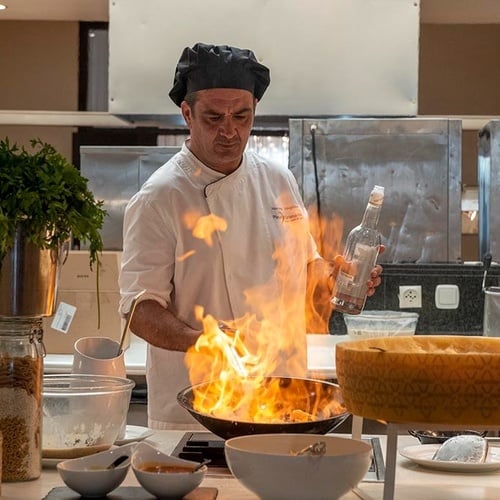 ein Raum mit weißen Tischen und Stühlen und einem Kronleuchter