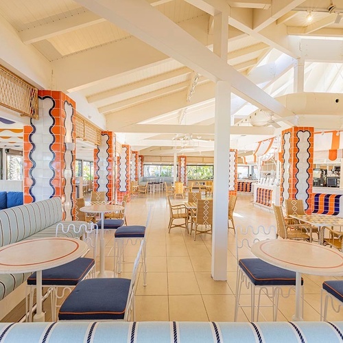 ein Raum mit weißen Tischen und Stühlen und einem Kronleuchter