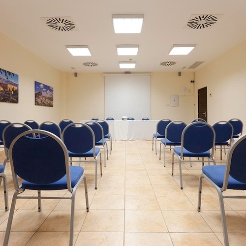 ein Raum mit weißen Tischen und Stühlen und einem Kronleuchter