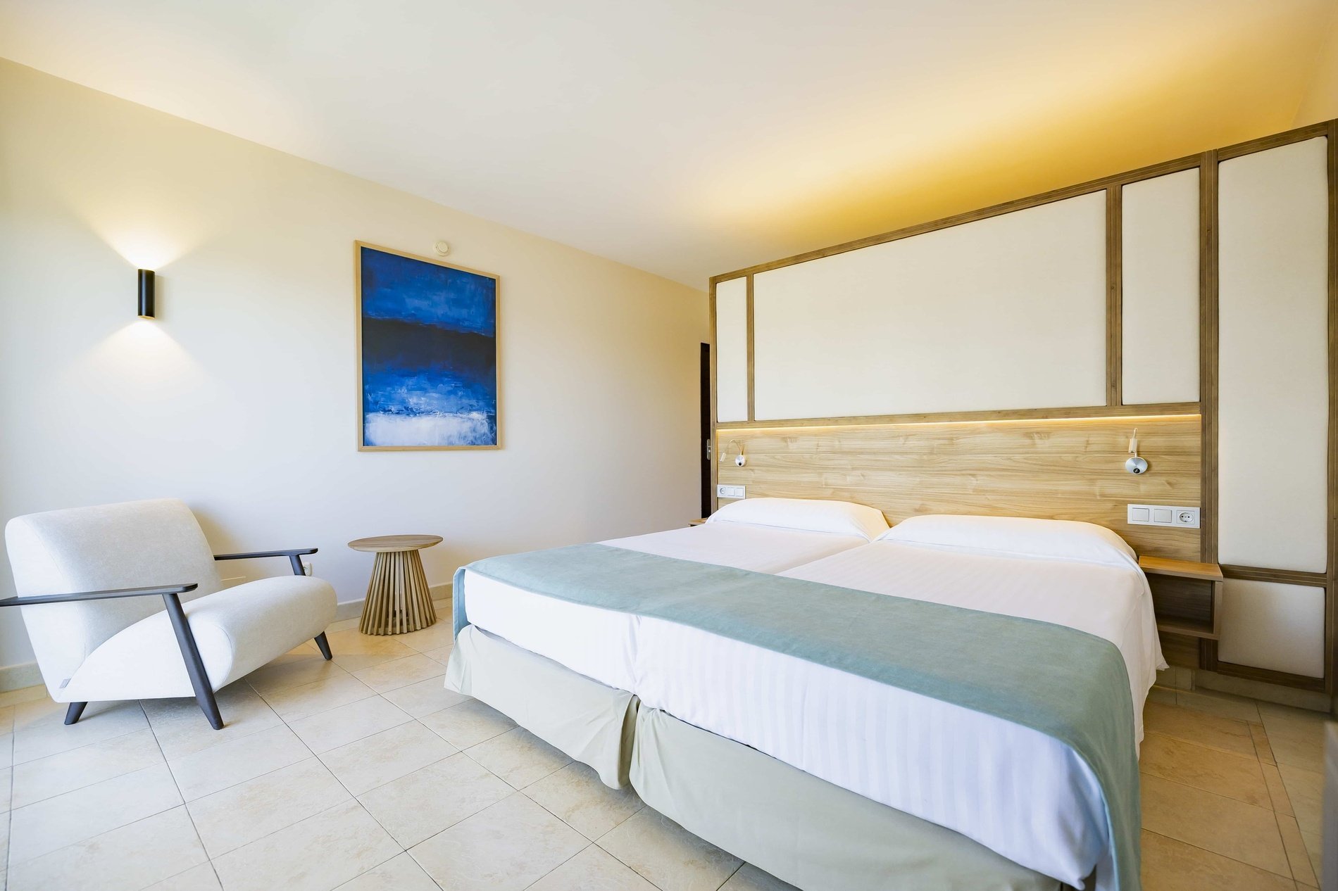 una habitación de hotel con una cama king size y un sofá azul