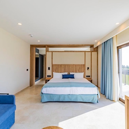 ein Hotelzimmer mit einem großen Bett und einer blauen Couch