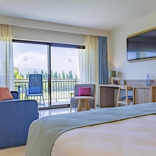 ein Balkon mit zwei Stühlen und einem Tisch mit einer Flasche Wasser darauf