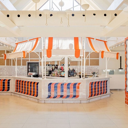 ein Raum mit weißen Tischen und Stühlen und einem Kronleuchter