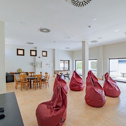 ein Wohnzimmer mit einem Tisch und Stühlen und einem Fernseher