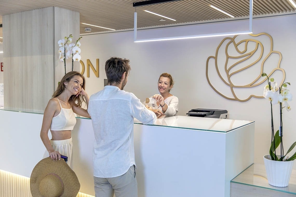 un hombre y una mujer están en la recepción de un hotel