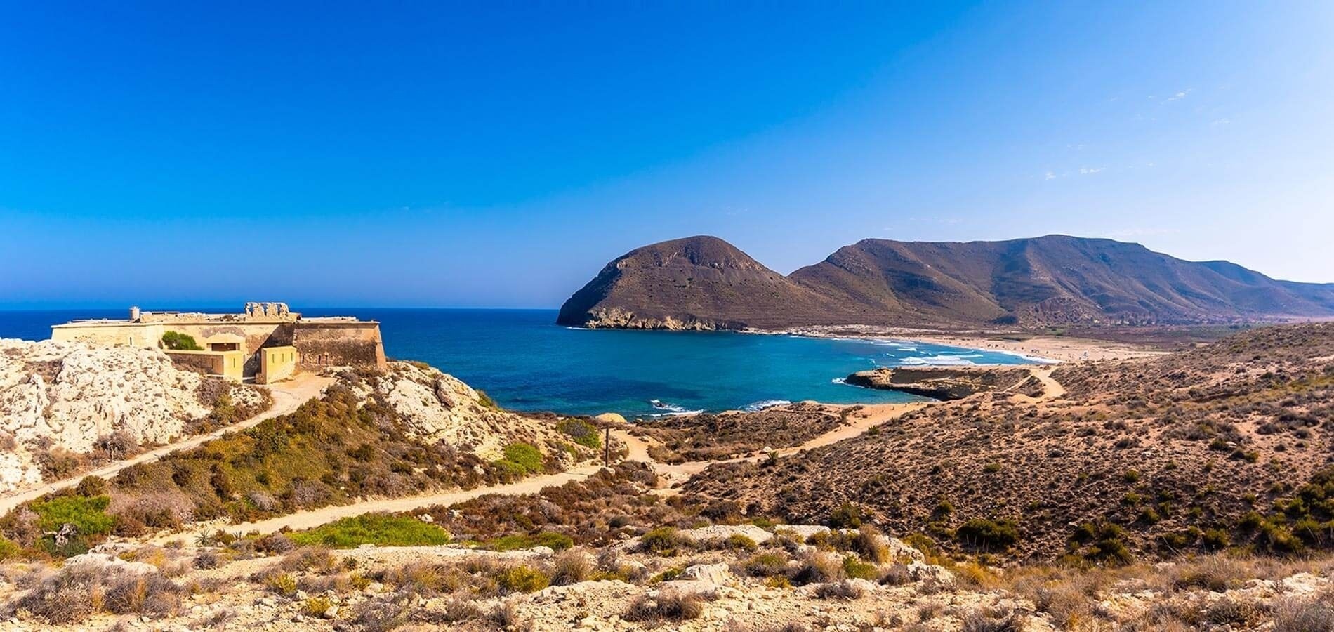 un edificio en la cima de una colina con vistas al océano