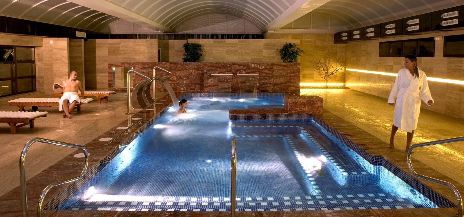 un hombre y una mujer se relajan en una piscina en un spa